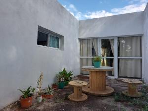 un patio con mesa y 2 bancos frente a un edificio en Vivienda en Cuchi Corral en Los Puquios