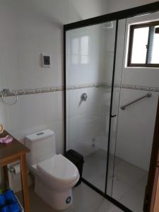 a bathroom with a toilet and a glass shower at Armonia - La Victoria - Tarija in Tarija
