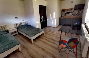 Zimmer mit 2 Betten, einem Tisch und einer Küche in der Unterkunft Privát SIMBA in Strečno