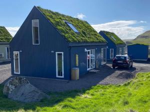 a blue house with a grass roof at Okkara summarhús á Sandi - Luxury cottage - Unique location in Sandur