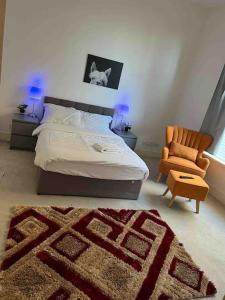 a bedroom with a bed and a chair and a rug at Model 2bedrooms flat London. in Woolwich