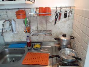 fregadero con olla y utensilios de cocina en Terrazzas 305 - Beira-Mar AR Wi-Fi Lavadora 02 camas de casal, en João Pessoa
