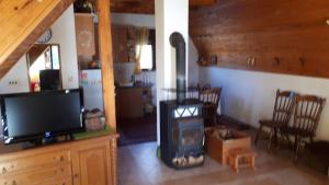 a living room with a fireplace and a tv at Kuća za odmor VITICA s vanjskim kaminom in Kupres