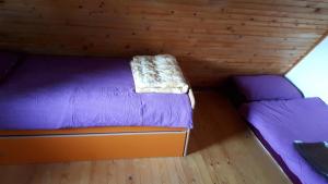 una piccola camera con due letti in una cabina di Kuća za odmor VITICA s vanjskim kaminom a Kupres