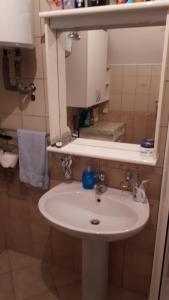 bagno con lavandino bianco e specchio di Kuća za odmor VITICA s vanjskim kaminom a Kupres