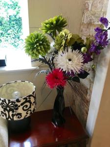 a vase filled with flowers sitting on a table at Ivy House Barn, Heckington in Heckington
