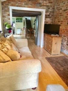 a dog laying on a couch in a living room at Ivy House Barn, Heckington in Heckington