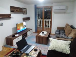 Vila Afan Ušivak في سراييفو: غرفة معيشة مع جهاز كمبيوتر محمول على طاولة