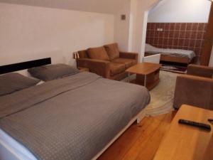 1 dormitorio con cama, sofá y mesa en Vila Afan Ušivak en Sarajevo