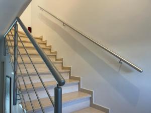 a staircase with a metal handrail and white stairs at VILLA DALU not only Holidays in Trani