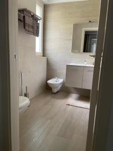 a bathroom with a toilet and a sink and a mirror at VILLA DALU not only Holidays in Trani
