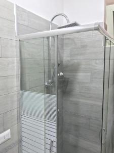 La salle de bains est pourvue d'une douche avec une porte en verre. dans l'établissement 'A Funtanella, à Naples
