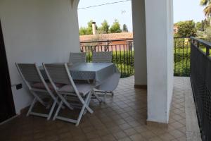 een patio met een tafel en stoelen op een balkon bij Big Family in Copertino