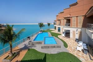 a house with a swimming pool next to the ocean at Indium Al Fayroz Chalets Durrat AlArus for families only in Durat  Alarous