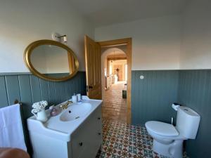 a bathroom with a sink and a toilet and a mirror at La Morera in Alcaraz