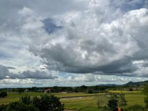 un cielo nublado sobre un campo verde con árboles en THE-SOMERSET INN & RESTAURANT, en Iloilo City