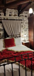 a bedroom with a bed with a stone wall at Αρχοντικό Ταξίμι (Μουντζουρίδη) in Argalasti