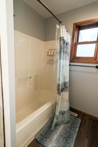 y baño con bañera y cortina de ducha. en Lake City - Family/Friend Hangout, Garage & Dog Friendly, en Lake City