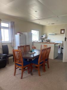 a kitchen and dining room with a table and chairs at Coastal Accommodation in Oamaru