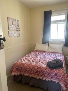 a small bedroom with a bed with a window at Coastal Accommodation in Oamaru