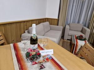 a bottle of wine sitting on a table with two glasses at Pirin Golf Private Apartments & Studios in Razlog