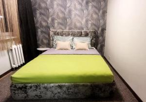 um quarto com uma cama com um cobertor verde em Apartment near Akropolis em Klaipėda