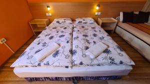 a bedroom with a bed with a blue and white comforter at Hajas Família Kiadó Szobák in Balatonmáriafürdő