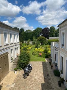 une moto garée dans la cour d'une maison dans l'établissement Au Jardin des Deux Ponts, à Abbeville