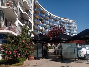 a building with umbrellas and flowers in front of it at Hermoso departamento frente al casino in Viña del Mar