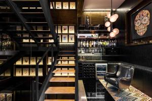 un bar con una escalera que conduce a una sala de cata de vinos en Luxurious Penthouse Oasis en Ciudad de México