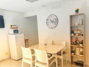 uma cozinha com mesa e cadeiras e um relógio na parede em The jewel of the coast em Sousse