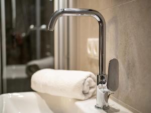 a bathroom sink with a faucet and a towel at Appartements ALMA in Mayrhofen