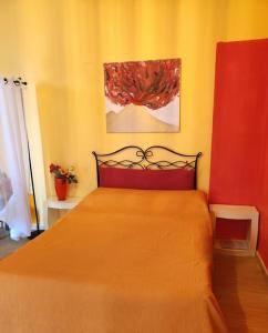 ナポリにあるPanoramico con terrazzoのベッドルーム1室(オレンジ色のベッドカバー付)