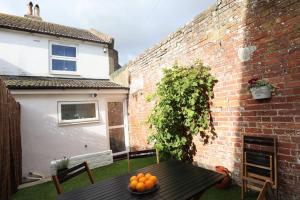 a table with oranges on it in a backyard at Cute Cottage 4 mins from Cafés Station and Sea in St. Leonards
