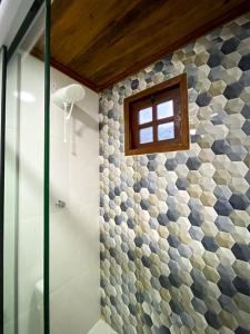 a bathroom with a shower with a window at Chalés Vila Do Vale in Vale do Capao +17 photos