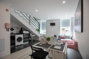 a living room with a table and a staircase at Aveiro´s Dock Apartments in Aveiro