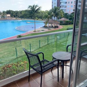 einen Balkon mit einem Tisch, Stühlen und einem Pool in der Unterkunft Departamento 'Hozanek' en Dream Lagoons Cancun in Cancún