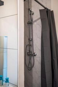 a shower in a bathroom with a shower curtain at T1bis Wifi 25m2 Lumineux Elégant, Roubaix Centre in Roubaix