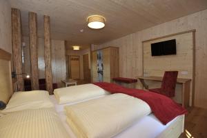 a bedroom with two beds and a table and a television at Gasthaus Reiter in Pinsdorf