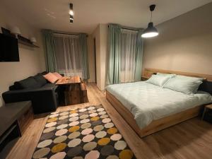 a bedroom with a bed and a couch and a table at Borovets Gardens - Studio E 27 in Borovets