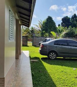un coche aparcado en un patio junto a una casa en Casa Bouganville apto triplo en Novo Airão