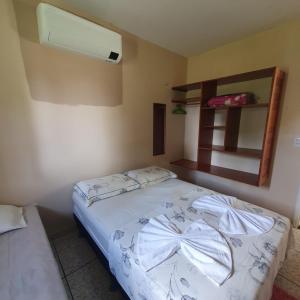 a bedroom with a bed with a white comforter at Casa Bouganville apto triplo in Novo Airão