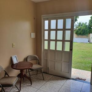 a room with a door and a table and chairs at Casa Bouganville apto triplo in Novo Airão