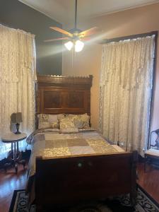 a bedroom with a bed and a ceiling fan at Grand Gables Inn in Palatka
