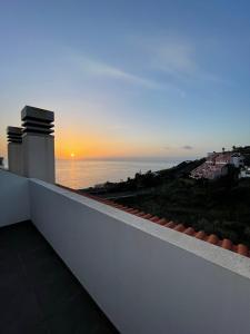 a view of the ocean from a balcony at sunset at Penthouse Palmeira in Gaula