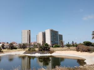 un estanque en la playa con edificios de fondo en VENEZIOLA DREAMS, feel like home, en La Manga del Mar Menor