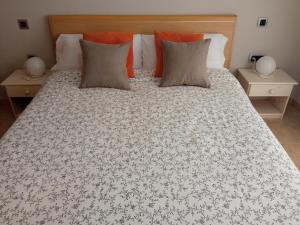 1 dormitorio con 1 cama grande con almohadas de color naranja en VENEZIOLA DREAMS, feel like home, en La Manga del Mar Menor
