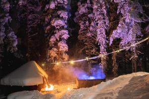 un focolare nella neve di notte di Raanakka House - Premium Villa at Levi a Levi