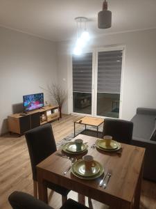 ein Wohnzimmer mit einem Holztisch und Stühlen in der Unterkunft Apartament Rumia z Garażem in Rumia