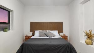 Schlafzimmer mit einem Bett mit einem Kopfteil aus Holz in der Unterkunft Hilltop in Uitenhage
